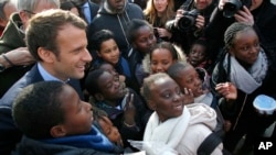 Independent centrist presidential candidate Emmanuel Macron poses with students of the Moliere school for a group photo in Les Mureaux, west of Paris, France, March 7, 2017.