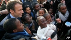 Independent centrist presidential candidate Emmanuel Macron poses with students of the Moliere school for a group photo in Les Mureaux, west of Paris, France, March 7, 2017.