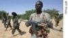 A JEM fighter escorts AU Force Commander General Martin Luther Agwai (third from left) and JEM's Khalil Ibrahim (second from left), in Darfur, October 2007. (AP)