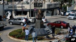 People gather near a statue of Iranian General Qassem Soleimani, who was the head of Iran's Quds force, that was installed to commemorate the anniversary of his killing, in a U.S. drone strike, in Lebanon, Jan. 6, 2021. 