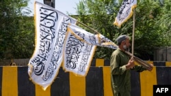 Seorang pria tampak menjual bendera Taliban di jalanan di Kota Kabul, Afghanistan, pada 13 Agustus 2024. (Foto: AFP/Wakil Kohsar)