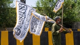 An Afghan man sells Taliban flags along a street on the eve of the third anniversary of Taliban takeover of Afghanistan, in Kabul on Aug. 13, 2024. 