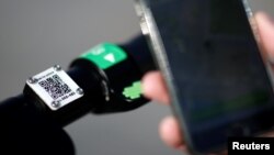 Lime’s France director Arthur-Louis Jacquier holds his mobile phone to use a dock-free electric scooter Lime-S by California-based bicycle sharing service Lime as he poses on their launch day in Paris, France, June 22, 2018. 