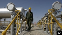 FILE - Iranian oil technician Majid Afshari makes his way to the oil separator facilities in Iran's Azadegan oil field southwest of Tehran, Iran, April 15, 2008.