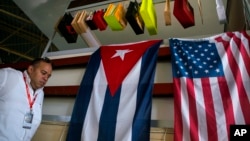 A man walks past Cuban and U.S. flags at the 33rd Havana International Fair (FIHAV) in Havana, Cuba, Nov. 2, 2015. 