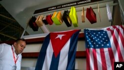 Foto de Archivo. Un hombre pasa delante de banderas de Cuba y EE.UU. en la 33ava. Feria Internacional de La Habana. Nov. 2, 2015. 