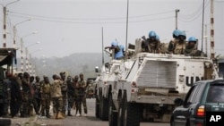 United Nations soldiers talk to forces loyal to Alassane Ouattara as they drive through a republican forces operating base on the outskirts of Abidjan, Ivory Coast, April 9, 2011.