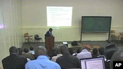 A tutor helps a class at the Kakuma Distance Learning Center in northern Kenya, Aug 2010