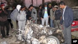 Residents and Iraqi soldiers inspect the site of a bomb attack in Hilla, 100 km (62 miles) south of Baghdad, December 5, 2011.