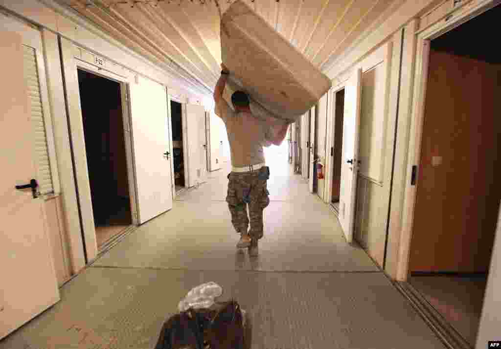 A soldier from the 3rd Brigade, 1st Cavalry Division carries a mattress while preparing to depart from Iraq at Camp Adder, Iraq, December 17, 2011. (Reuters)