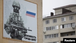 A banner depicting a Russian serviceman is seen on a military barrack building at the base of 247th Air Assault Regiment in the southern city of Stavropol, Russia, Feb. 25, 2016.