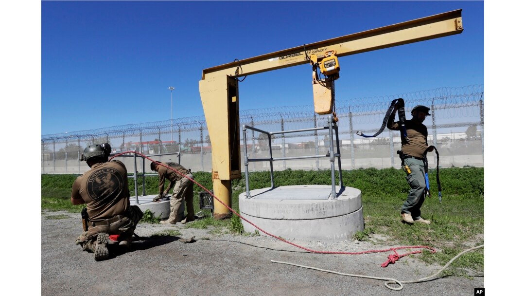Members of the Border Patrol's Border Tunnel Entry Team work near a tunnel entrance in between two border barriers separating San Diego and Tijuana, Mexico, in San Diego, March 6, 2017.