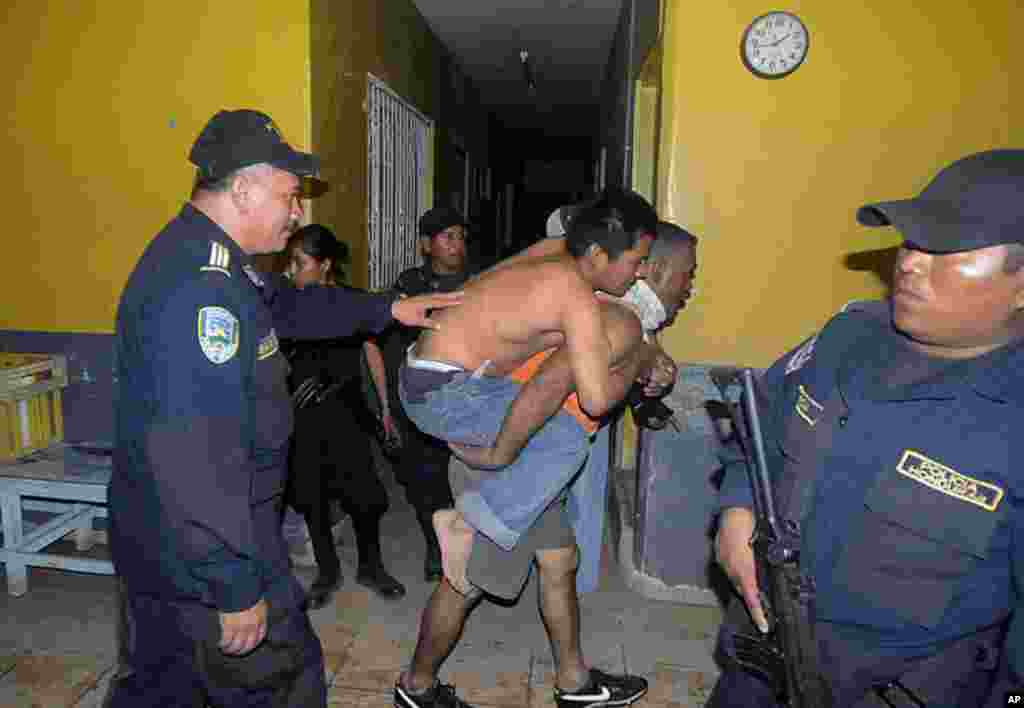 An injured inmate is carried away after a fire broke out at the prison in Comayagua, Honduras. The fire claimed the lives of hundreds of inmates. (AP)