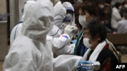 Cư dân di tản từ khu vực gần nhà máy điện hạt nhân được kiểm tra mức độ nhiễm phóng xạ tại một trung tâm thử nghiệm ở thành phố Koriyama, miền bắc Nhật Bản