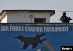 FILE - An Indian security personnel stands guard on a building at the Indian Air Force (IAF) base at Pathankot in Punjab, India, Jan. 5, 2016.