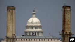 Tư liệu - Tòa nhà Quốc hội Mỹ đằng sau hai cột tháp của Nhà máy Điện Quốc hội ở Washington, ngày 24 tháng 6, 2013