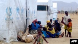 FILE - Nigerian refugees sit by a UNHCR tent in the refugee camp of Minawao, on the border of Nigeria at the extreme north of Cameroon, March 29, 2014. 