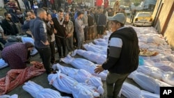 FILE—Palestinians check the bodies of people killed by Israeli airstrikes on Jabaliya refugee camp, at the Indonesian hospital, northern Gaza Strip, Saturday, Nov. 18, 2023.
