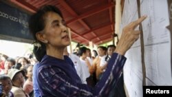 Myanmar pro-democracy leader Aung San Suu Kyi checks a voters list during her door-to-door visits for voter education campaign at Warheinkha village, in her constituency town Khawhmu, outside Yangon on July 4, 2015. Suu Kyi's National League for Democracy