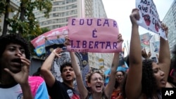 FILE - A student holds a sign that reads in Portuguese "To Educate is Freedom" during a protest against the budget cuts by President Jair Bolsonaro´s government of public schools and universities, in Rio de Janeiro, Brazil, Tuesday, Oct. 18, 2022. (AP Photo/Silvia Izquierdo)