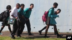 FILE - Students leave school at the end of the day in a suburb of Johannesburg, South Africa.