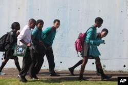 FILE - Students leave school at the end of the day in a suburb of Johannesburg, South Africa.