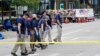 Members of the FBI's evidence response team walk the scene one day after a mass shooting in downtown Highland Park, Ill. Tuesday, July 5, 2022. (AP Photo/Charles Rex Arbogast)