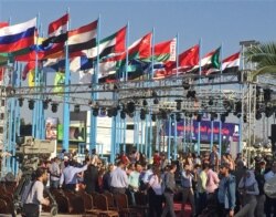 FILE - People attend Syria’s first international trade fair since war broke out in 2011, a few kilometers away from the rebel-held eastern suburbs of Damascus, Syria, Aug. 17, 2017.