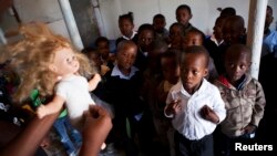 FILE - A volunteer from Simelela, an organization dealing with sexual violence, uses a doll to teach children about inappropriate touching and sexual abuse, at a pre-school in Cape Town's Khayelitsha township.