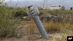 An unexploded projectile of multiple rocket launcher stuck into land near a settlement in self-proclaimed Republic of Nagorno-Karabakh, Azerbaijan, Oct. 1, 2020.