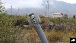 An unexploded projectile of multiple rocket launcher stuck into land near a settlement in self-proclaimed Republic of Nagorno-Karabakh, Azerbaijan, Oct. 1, 2020.