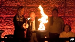 Holocaust survivor Robert Tomashof and his daughter Rutti Tomashof light a torch during the opening ceremony of the Holocaust Remembrance Day at the Yad Vashem Holocaust Memorial in Jerusalem, May 4, 2016.