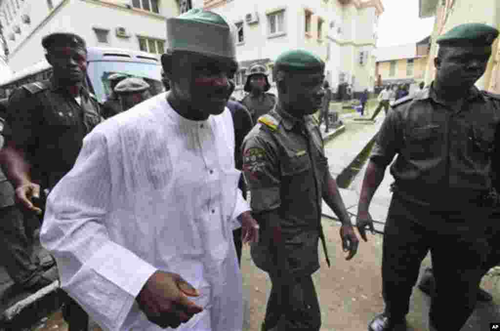 In this Monday Aug. 8, 2011 photo, Nigeria's former Chief security officer, Maj. Hamza Al-Mustapha, center, arrives for his trial at the federal high court in Lagos, Nigeria.