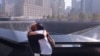 دو نفر از بازماندگان حملات تروریستی ۱۱ سپتامبر مقابل بنای یادبود ساخته شده به جای دو برج دو قلوی مرکز تجارت جهانی نیویورک