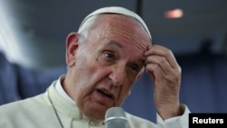 Le pape François fait un geste lors d'une conférence de presse à bord de son avion lors du vol de retour d'un voyage au Chili et au Pérou, le 22 janvier 2018.