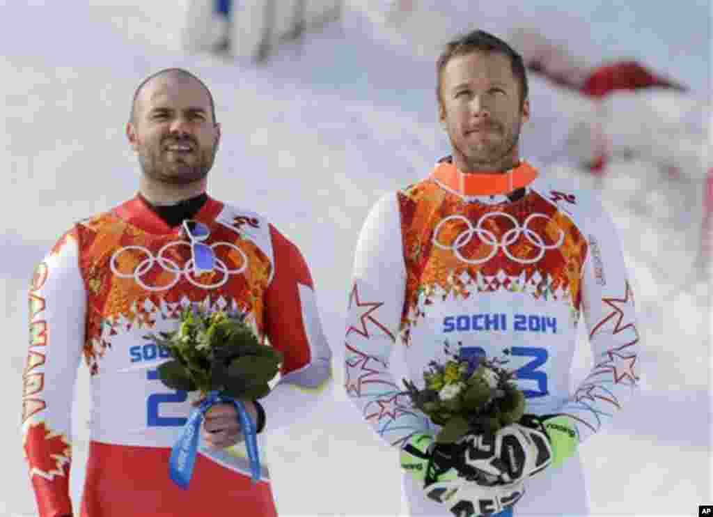 Men's super-G joint bronze medal winners Canada's Jan Hudec, left, and United States' Bode Miller stand on the podium during a flower ceremony at the Sochi 2014 Winter Olympics, Sunday, Feb. 16, 2014, in Krasnaya Polyana, Russia. (AP Photo/Christophe En