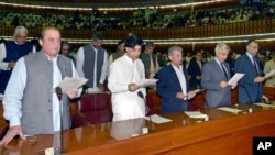 Incoming PM Nawaz Sharif (L) takes the oath of office with other newly-elected parliamentarians during the first session of the National Assembly in Islamabad, June 1, 2013.