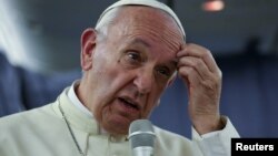 Pope Francis gestures during a news conference on board the plane during his flight back from a trip to Chile and Peru, Jan. 22, 2018. 