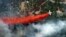 An aircraft lays down a line of fire retardant between a wildfire and homes in the dry, densely wooded Black Forest area northeast of Colorado Springs, Colorado, June 13, 2013.