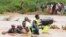 FILE —Residents cross a road damaged by El Niño rains in Tula, Tana River county in Kenya on November 25, 2023. Severe flooding in the country has killed at least 71 people and displaced thousands, according to estimates from the UN.