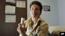 Dr. Lisa Sterman holds a bottle of Truvada pills that she prescribes for about a dozen patients at high risk for developing AIDS, at her office in San Francisco, May 10, 2012.