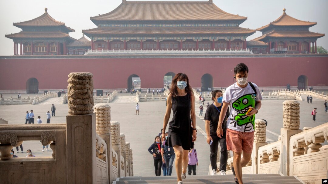 Para pengunjung mengenakan masker untuk melindungi dari penularan virus corona di Kota Terlarang, Beijing, 1 Mei 2020. (Foto: AP) 