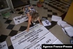 A municipal worker organizes final details of a polling station at the Republica da Siria high school in Santiago, Dec. 18, 2021, on the eve of the runoff presidential elections.