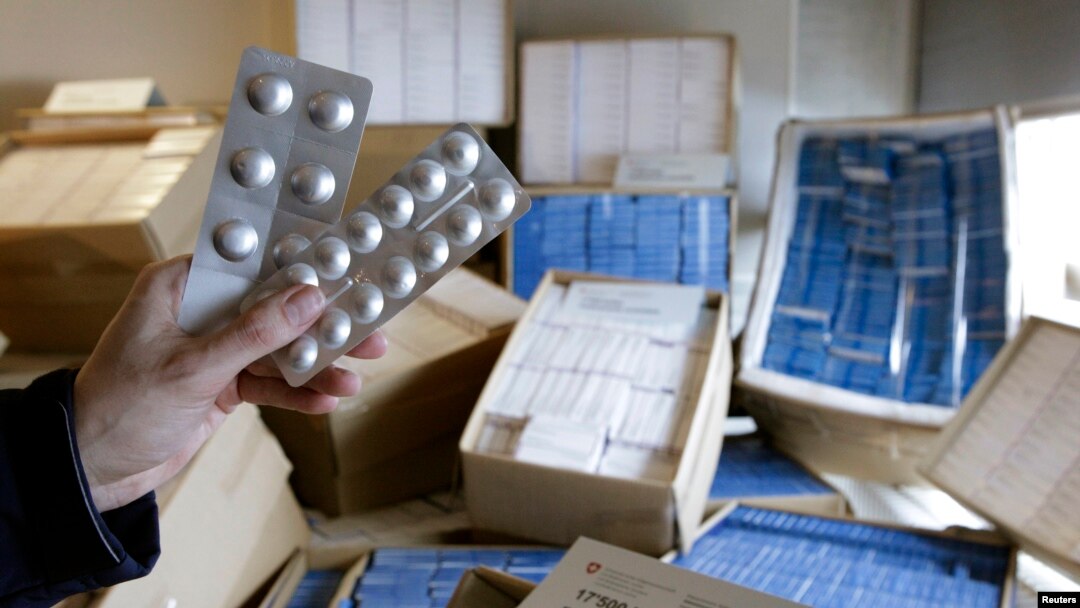 FILE - A Swiss customs officer holds up counterfeit medication in Bardonnex, near Geneva, February 10, 2010.