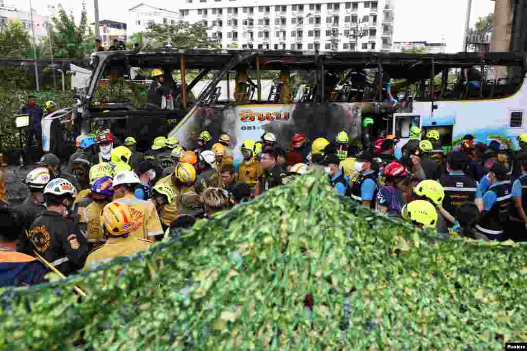 Penutup hijau dipasang saat petugas pemadam kebakaran mengeluarkan jenazah dari bus yang terbakar yang membawa guru dan siswa dari sekolah Wat Khao Phraya, di pinggiran Bangkok, Thailand, dalam insiden yang menewaskan sedikitnya 25 orang. (Reuters)&nbsp;