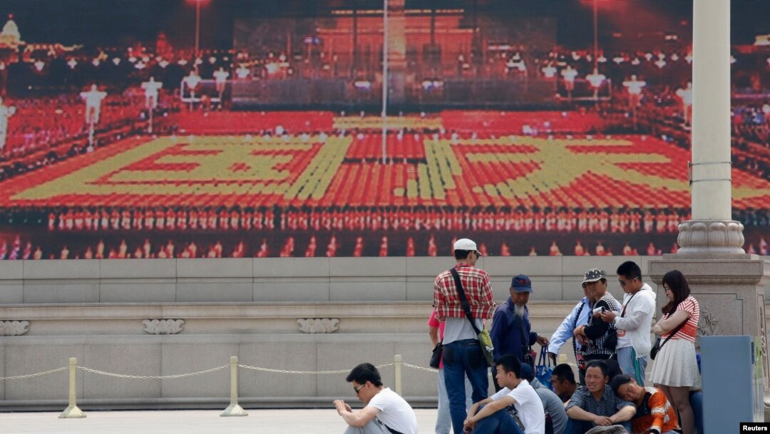 Para pengunjung beristirahat di depan layar lebar yang menayangkan video propaganda di Lapangan Tiananmen di Beijing (31/5). Kelompok aktivis "Para Ibu Tiananmen" menuntut agar para pemimpin China memulai dialog dan menilai kembali penindakan di Lapangan Tiananmen di Beijing tanggal 4 Juni 1989, yang menewaskan hampir tiga ribu pemrotes.