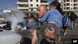 A Lebanese army soldier carries two injured children away from the site of an explosion near the Kuwaiti Embassy and Iran's cultural center, in the suburb of Beir Hassan, Beirut, Lebanon, Wednesday, Feb. 19, 2014. The bombing in a Shiite district in south