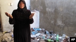 A resident of Bustan al-Qusr complains about trash left in her home by Syrian soldiers who took over her house during summer fighting in Aleppo, August 5, 2012.