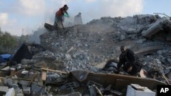 Người Palestine tìm kiếm người sống sót sau khi một tòa nhà trúng tên lửa của Israel ở Rafah.