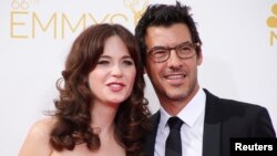 Aktris Zooey Deschanel, dari film komedi yang ditayangkan di stasiun TV Fox, "New Girl," tiba bersama Jacob Pechenik di Emmy Awards ke-66 di Los Angeles, California.